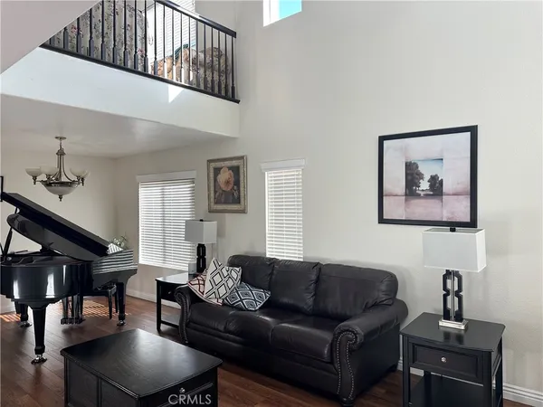 a living room with furniture a piano and a window