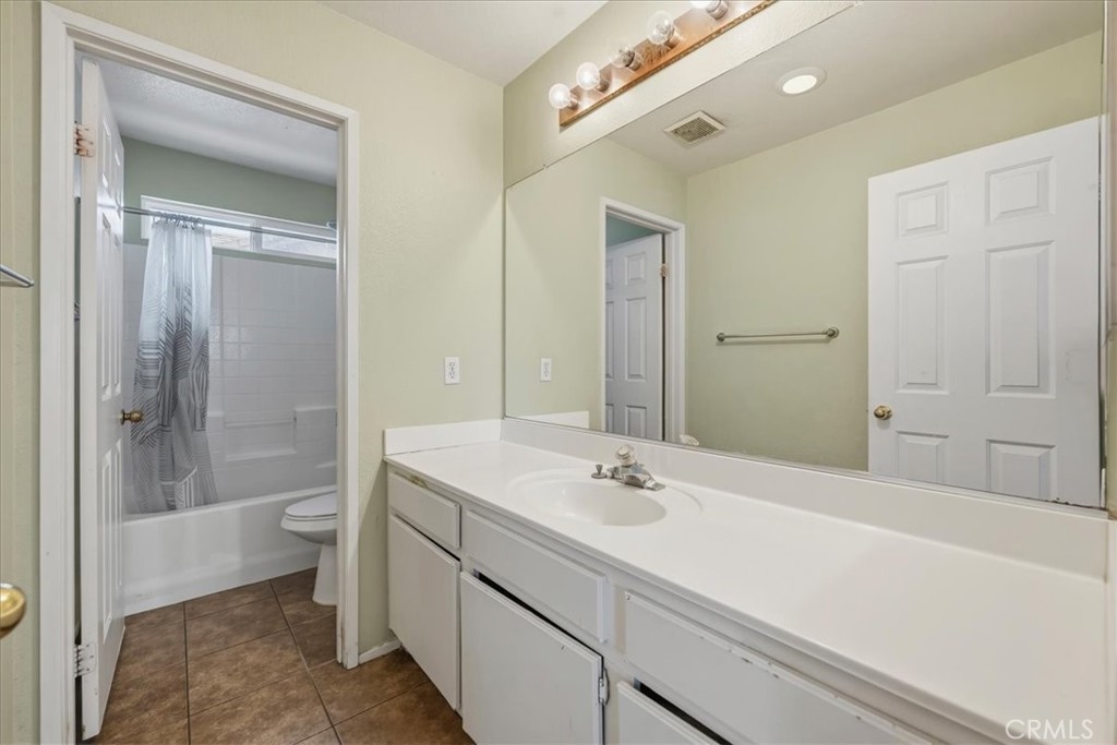 16220 Vía Ultimo Moreno Valley, CA 92551 - Photo 31 of 38 a bathroom with a sink a toilet and shower