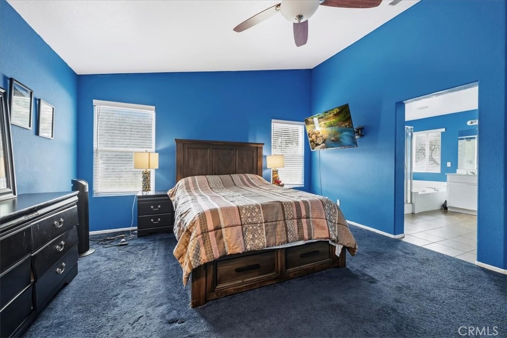 16220 Vía Ultimo Moreno Valley, CA 92551 - Photo 34 of 38 a bedroom with a bed and a chandelier