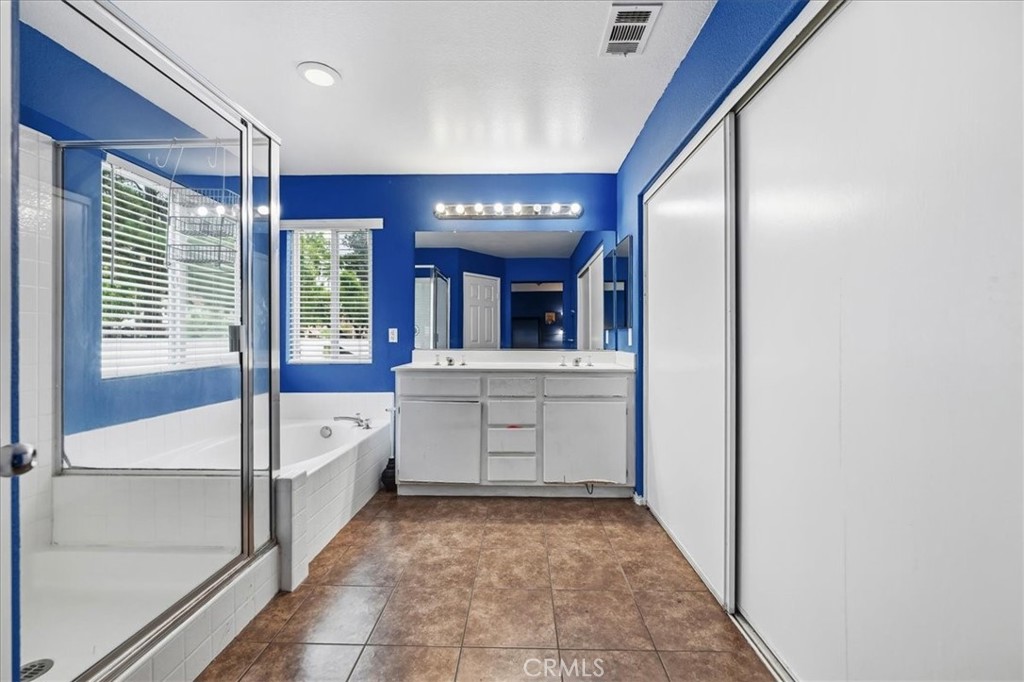 16220 Vía Ultimo Moreno Valley, CA 92551 - Photo 35 of 38 a bathroom with a sink a large mirror and a bathtub