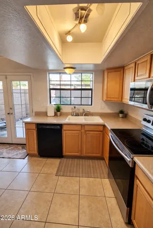a kitchen with a sink window and cabinets
