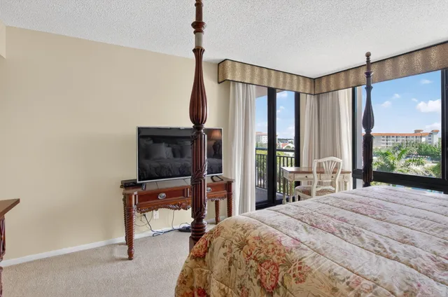 a bedroom with a bed window and a flat tv screen