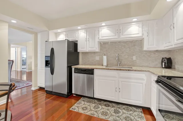 a kitchen with stainless steel appliances a refrigerator sink and cabinets