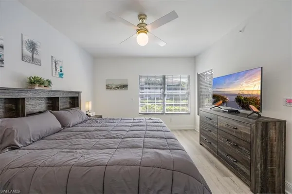 a bedroom with a large bed and a flat tv screen on dresser