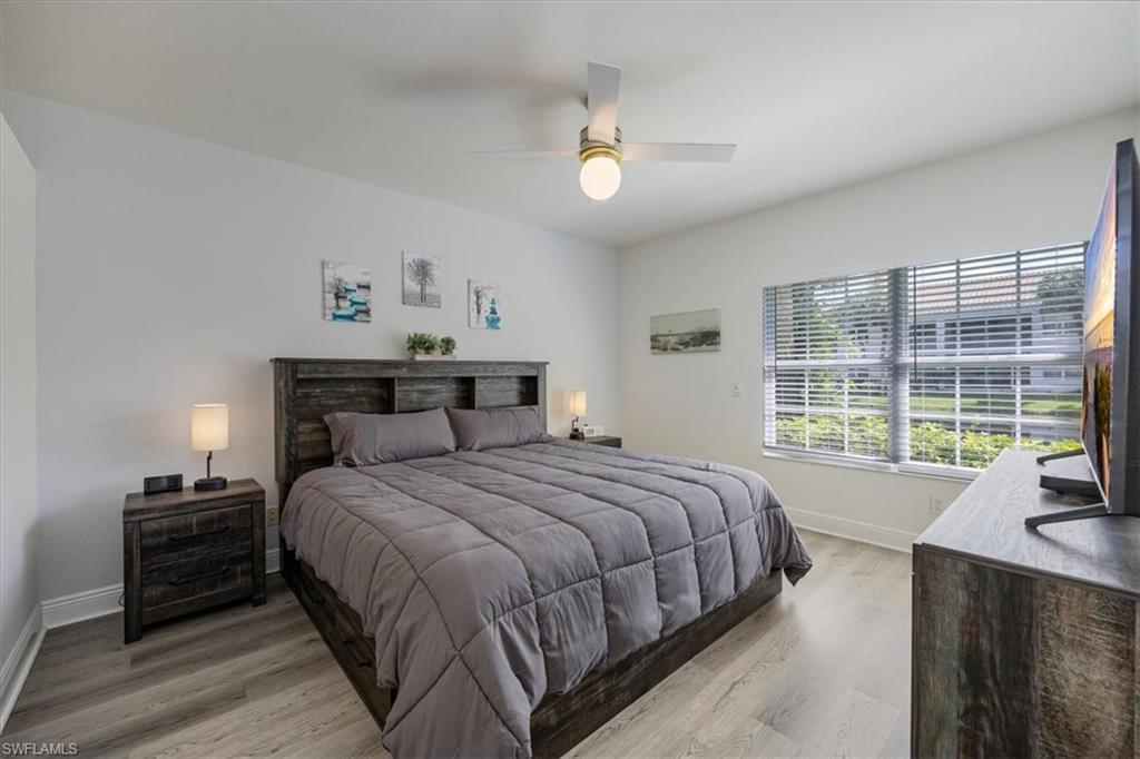 6914 Satinleaf Road North, Unit 103 Naples, FL 34109 - Photo 15 of 34 a bedroom with a large bed and a large window