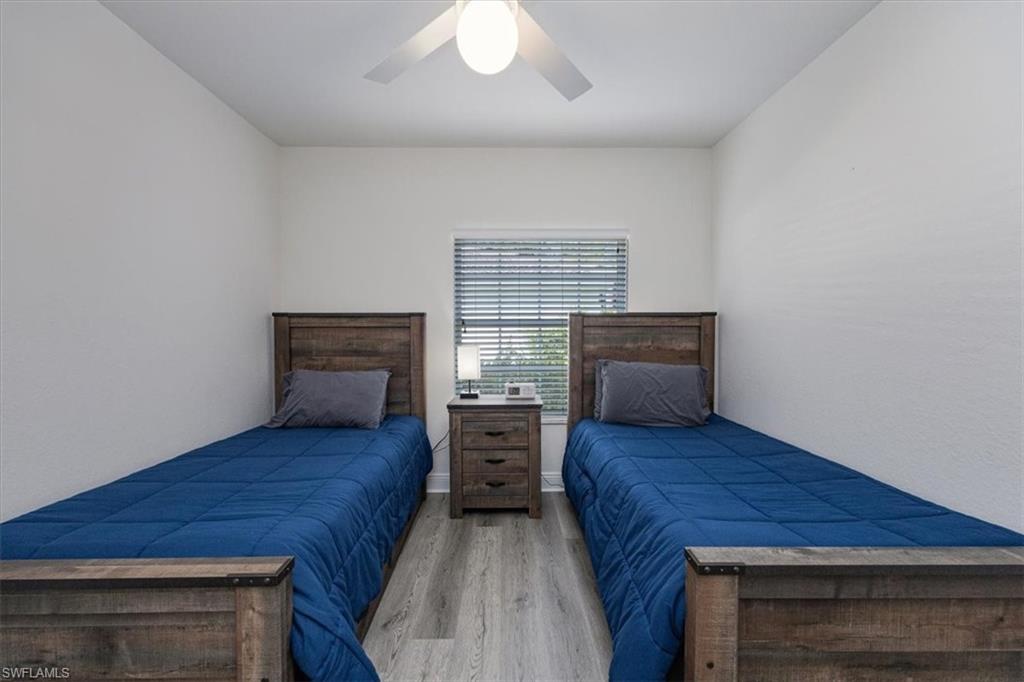 6914 Satinleaf Road North, Unit 103 Naples, FL 34109 - Photo 17 of 34 a bedroom with a bed and furniture