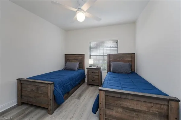 a bedroom with wooden floor and window
