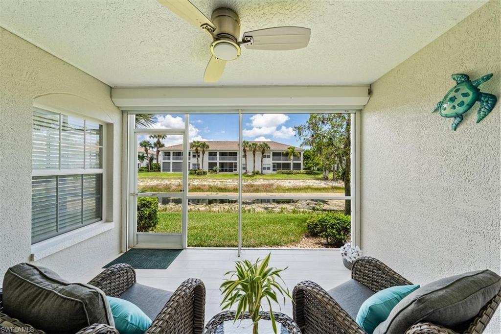 6914 Satinleaf Road North, Unit 103 Naples, FL 34109 - Photo 20 of 34 a living room with furniture and a floor to ceiling window