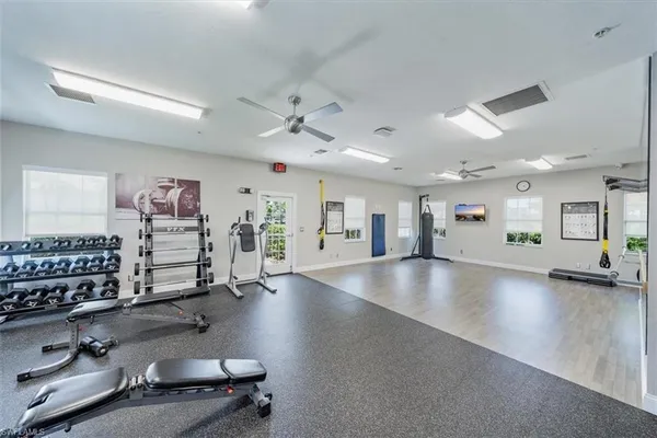 an empty room with windows and ceiling fan