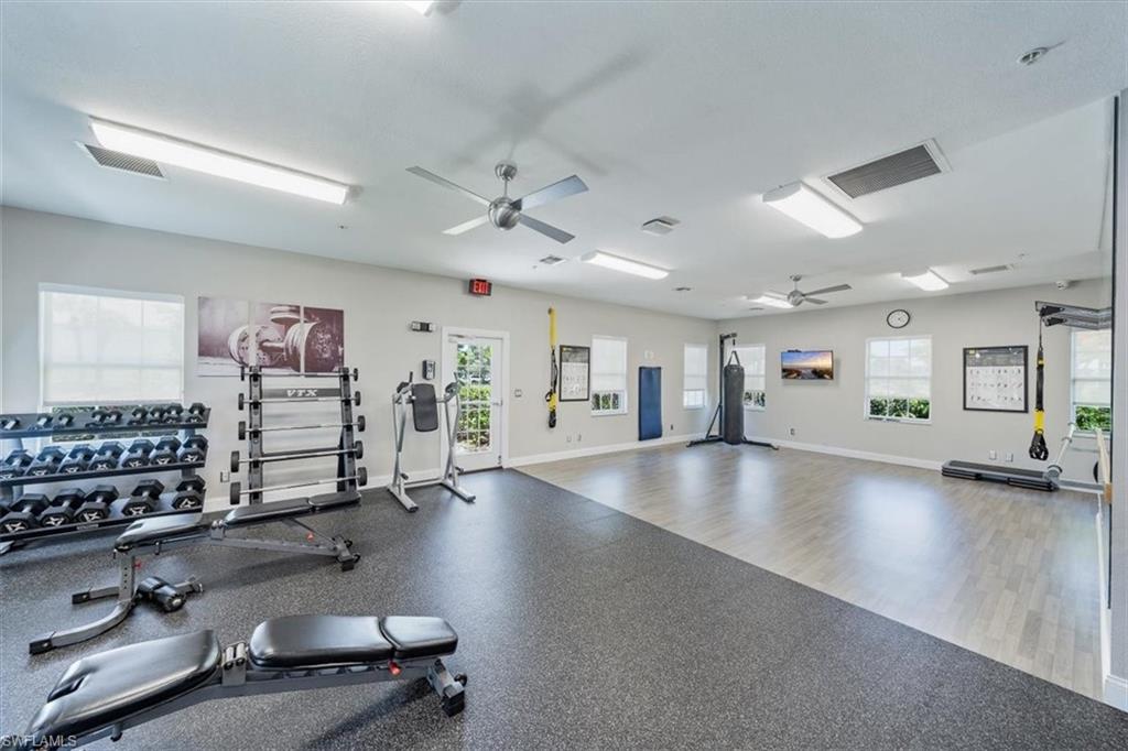 6914 Satinleaf Road North, Unit 103 Naples, FL 34109 - Photo 31 of 34 an empty room with windows and ceiling fan