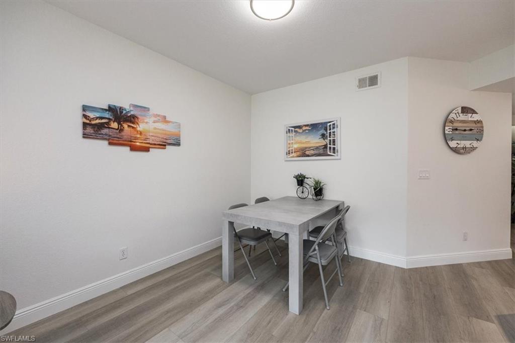 6914 Satinleaf Road North, Unit 103 Naples, FL 34109 - Photo 6 of 34 a view of a workspace with furniture and wooden floor
