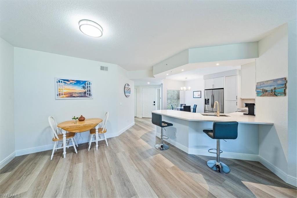 6914 Satinleaf Road North, Unit 103 Naples, FL 34109 - Photo 7 of 34 a view of a room with furniture and wooden floor