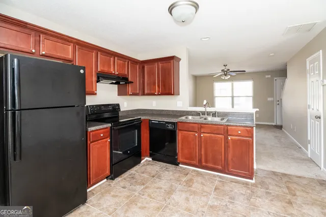 a kitchen with stainless steel appliances granite countertop a refrigerator a stove a sink and a granite counter tops