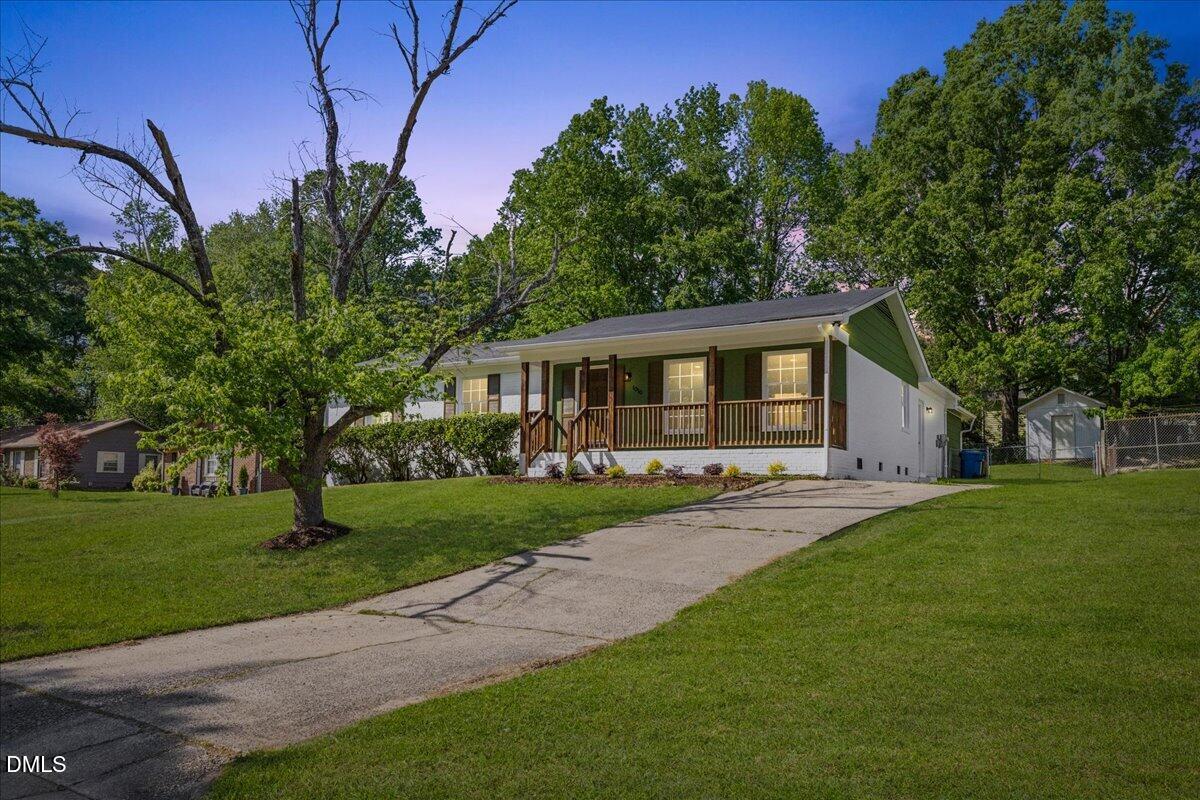 a front view of a house with a yard and trees
