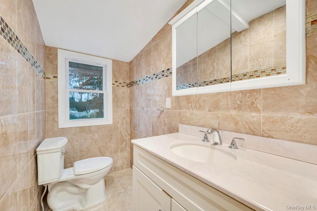64 Fox Place Hicksville, NY 11801 - Photo 17 of 25 Bathroom with tile walls and vanity