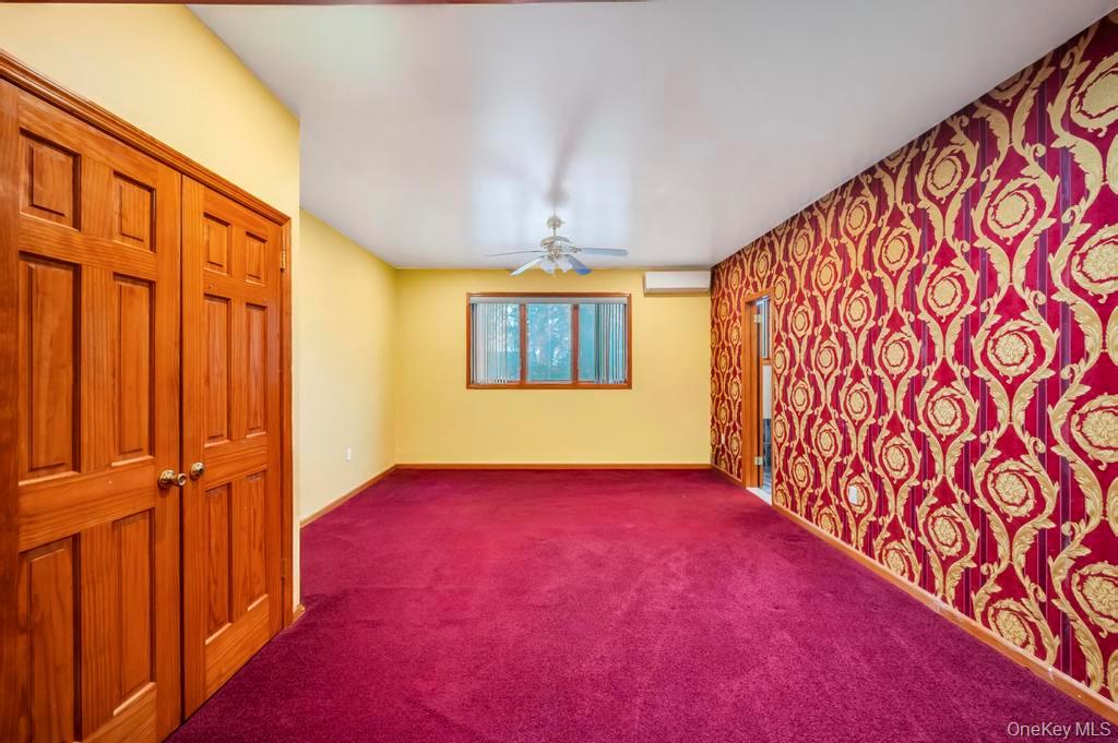 64 Fox Place Hicksville, NY 11801 - Photo 18 of 25 Empty room featuring carpet floors, ceiling fan, and a wall unit AC