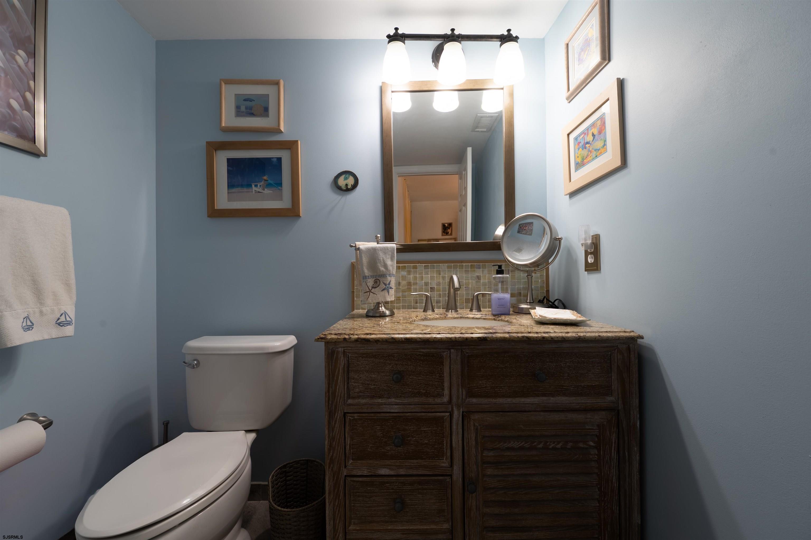 19 Bramble Drive Brigantine, NJ 08203 - Photo 14 of 15 a bathroom with a toilet a sink and mirror