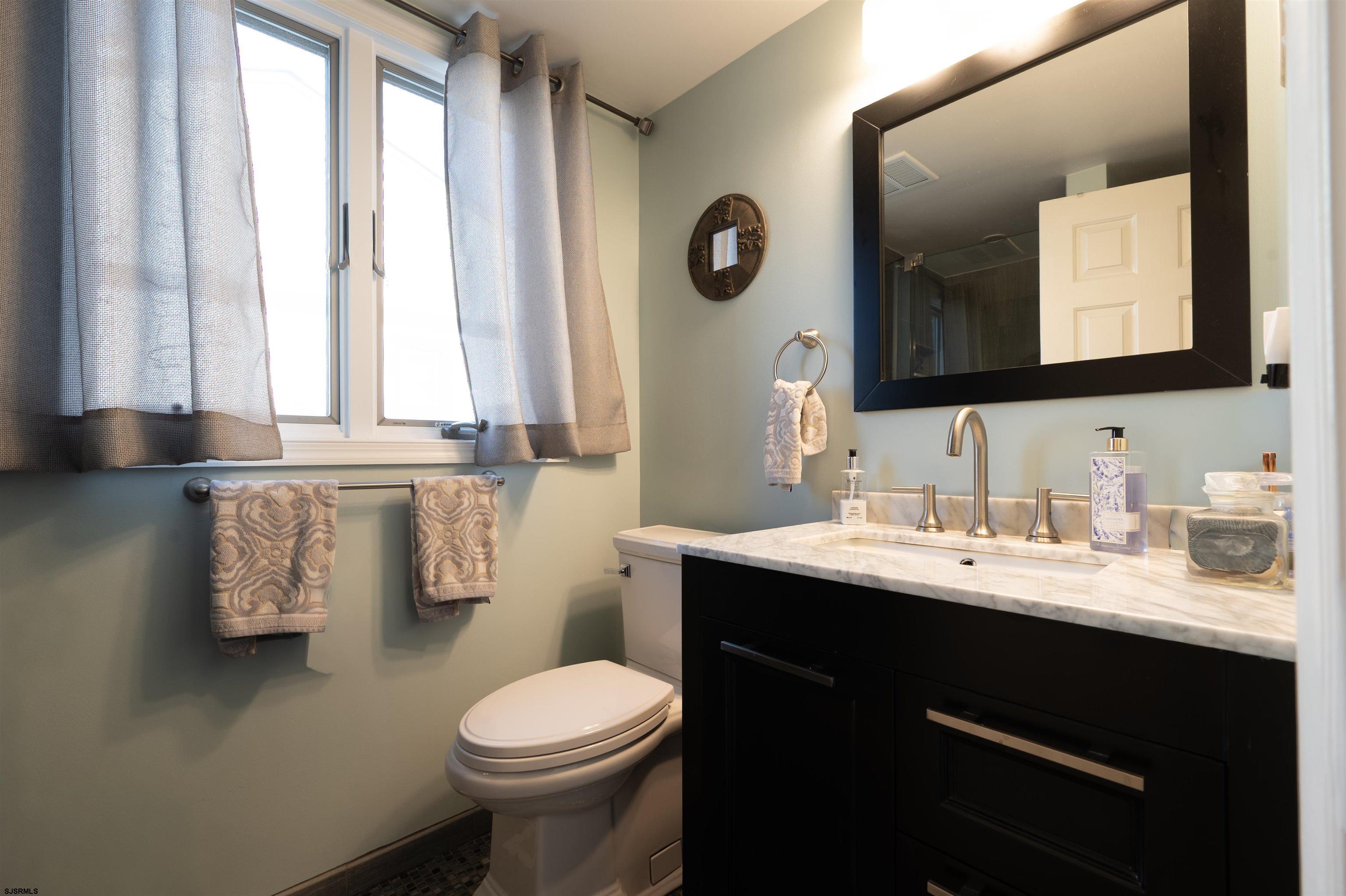 19 Bramble Drive Brigantine, NJ 08203 - Photo 15 of 15 a bathroom with a toilet sink and mirror