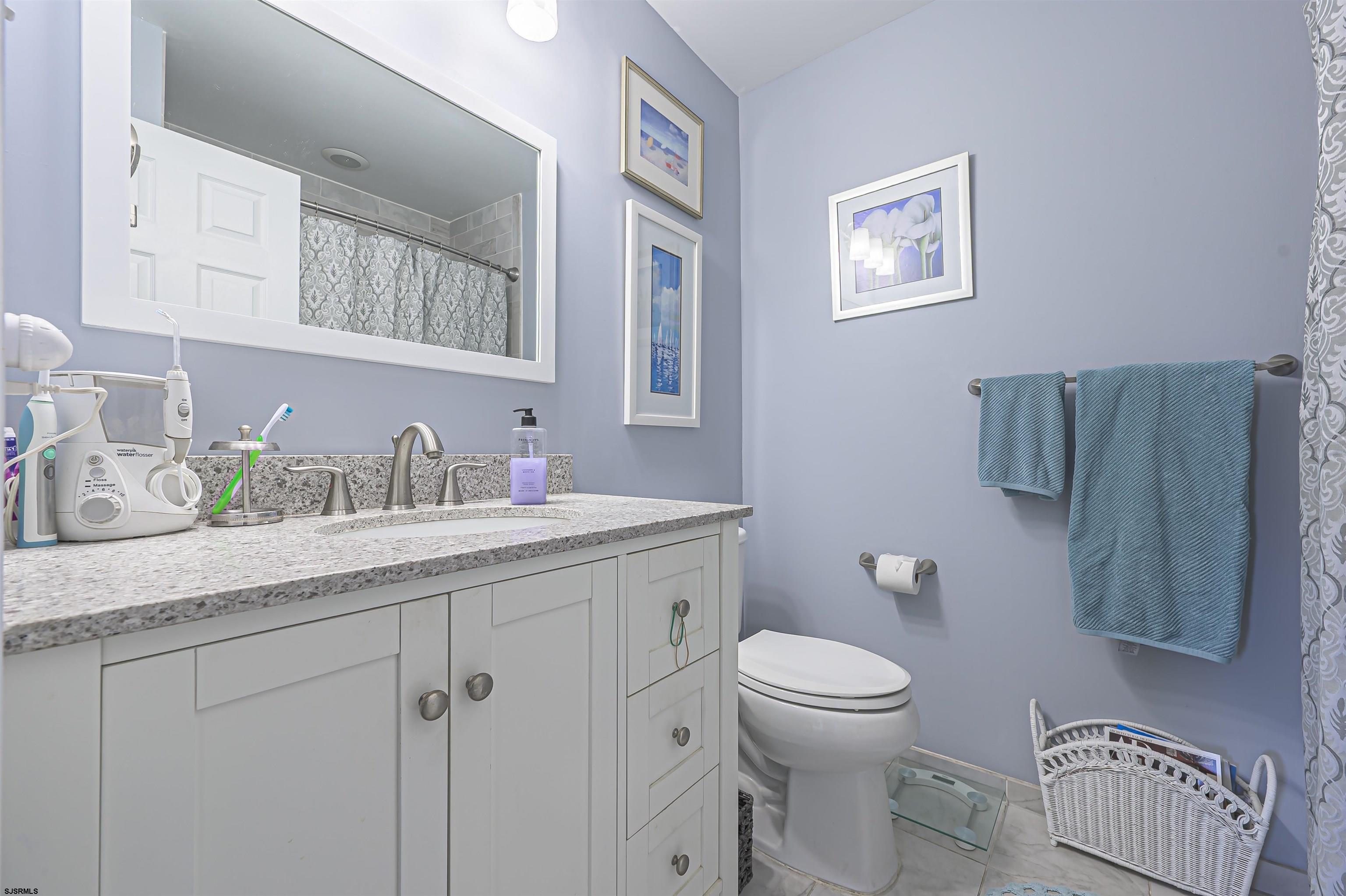 19 Bramble Drive Brigantine, NJ 08203 - Photo 7 of 15 a bathroom with a granite countertop sink a toilet and a mirror