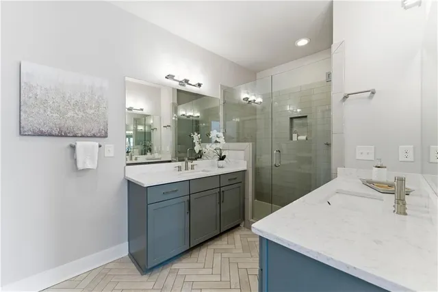 a bathroom with a sink vanity granite tub shower and a mirror