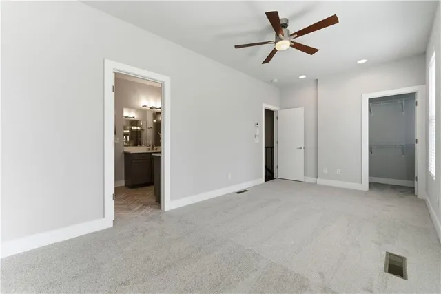 an empty room with closet and a ceiling fan