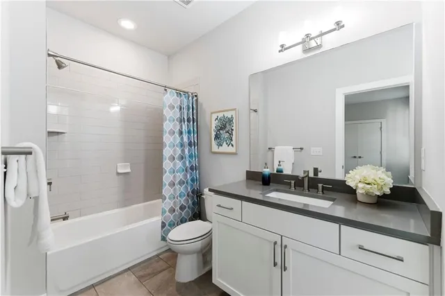a bathroom with a granite countertop sink a toilet and bathtub