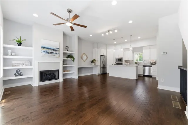 a view of a living room and kitchen with fireplace wooden floor