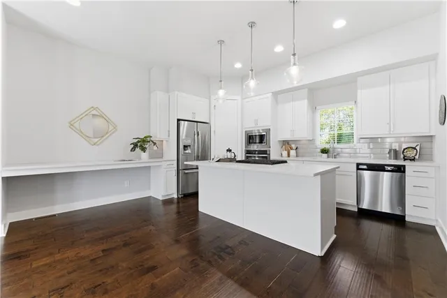 a kitchen with cabinets and wooden floor