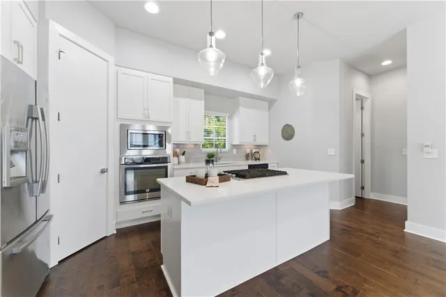 a kitchen with kitchen island a sink appliances and a refrigerator