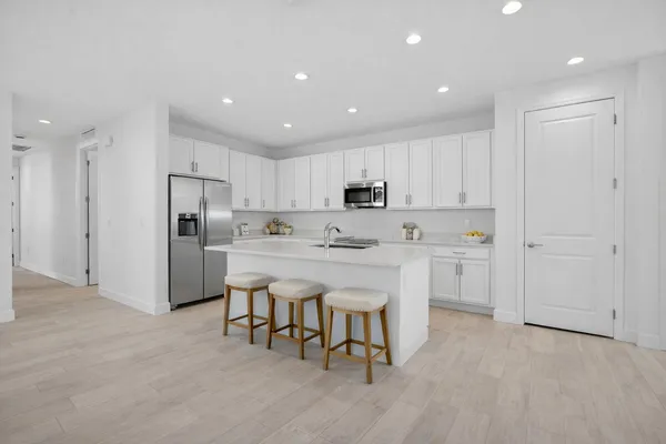 a kitchen with white cabinets and stainless steel appliances
