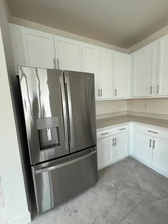 a kitchen with white cabinets sink and stove