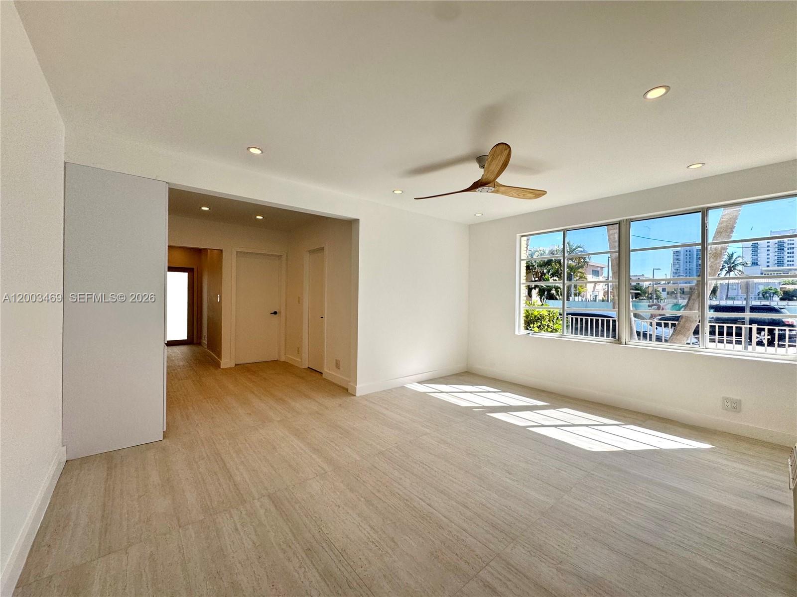 a view of empty room with wooden floor and windows