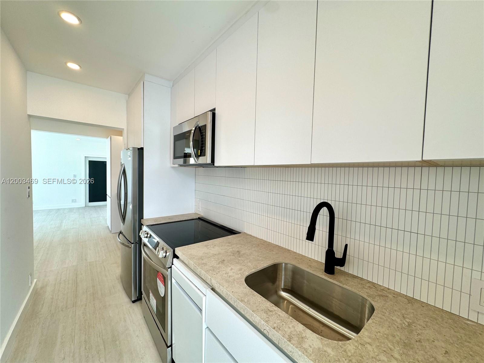 6944 Byron Avenue, Unit 1 Miami Beach, FL 33141 - Photo 12 of 15 a kitchen with a sink and a refrigerator