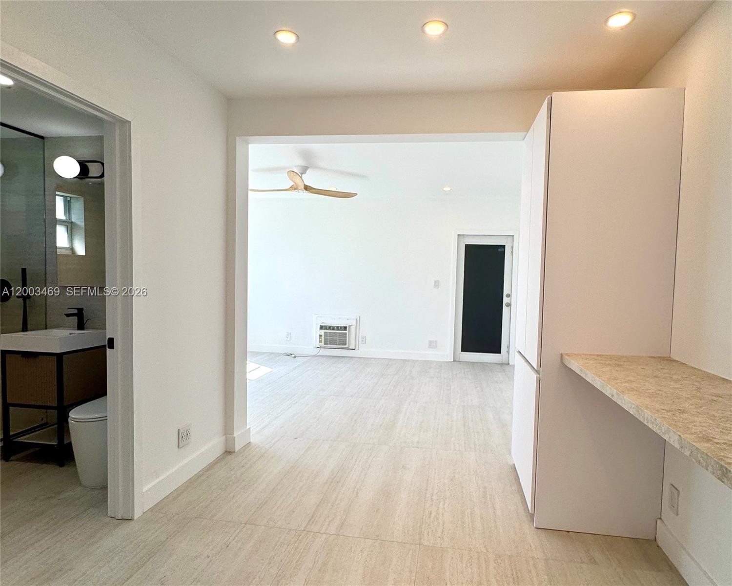 6944 Byron Avenue, Unit 1 Miami Beach, FL 33141 - Photo 13 of 15 a view of an empty room with wooden floor and a bathroom