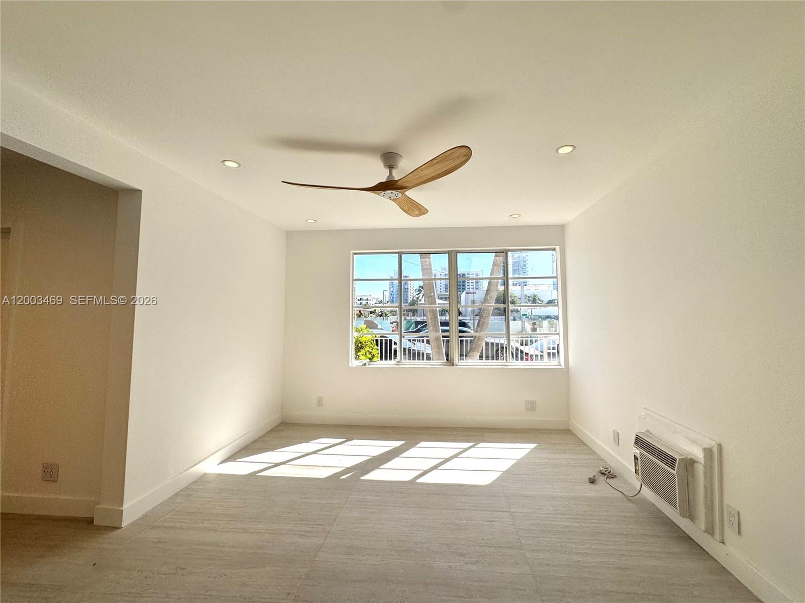 6944 Byron Avenue, Unit 1 Miami Beach, FL 33141 - Photo 2 of 15 a view of empty room with wooden floor and fan