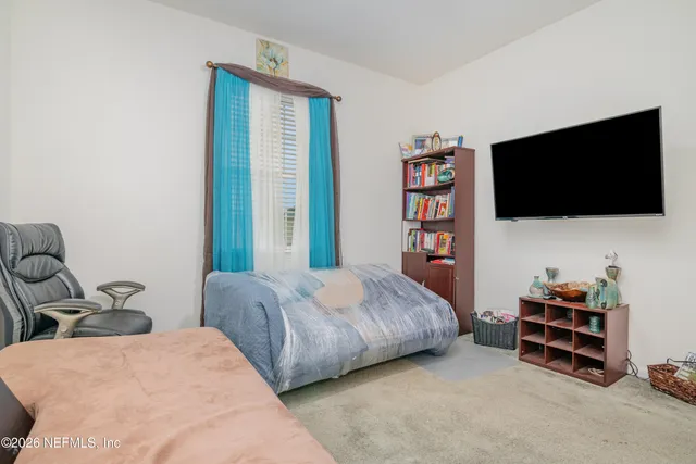 a bedroom with two beds and a flat screen tv
