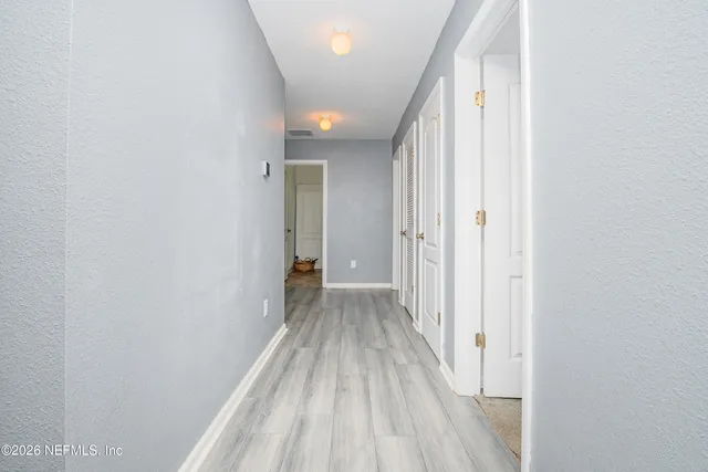 a view of a hallway with wooden floor