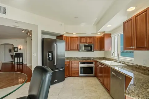 a kitchen with granite countertop cabinets and chairs