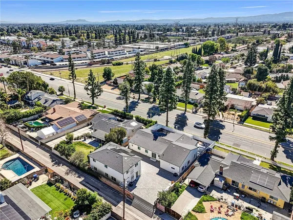an aerial view of a city with lots of residential buildings ocean and mountain view in back