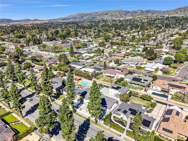 an aerial view of residential houses with outdoor space and trees
