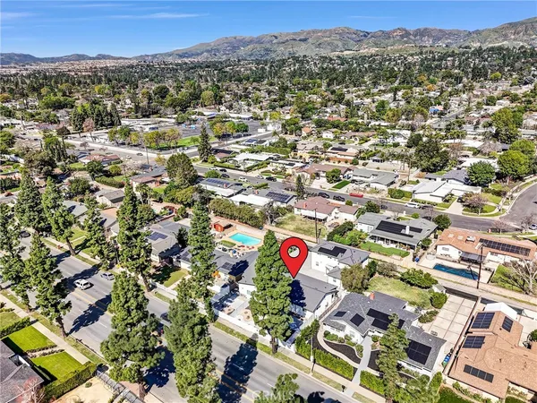 an aerial view of residential houses with outdoor space and street view