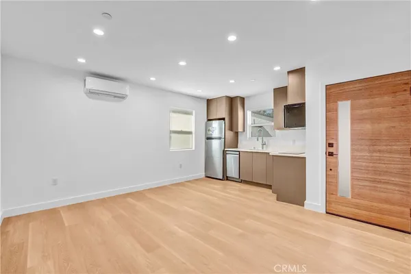 a view of a kitchen with a sink and dishwasher a refrigerator with wooden floor