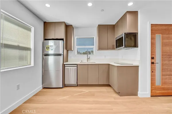 a kitchen with stainless steel appliances granite countertop a refrigerator and a sink