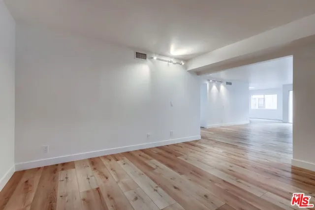 a view of an empty room and wooden floor