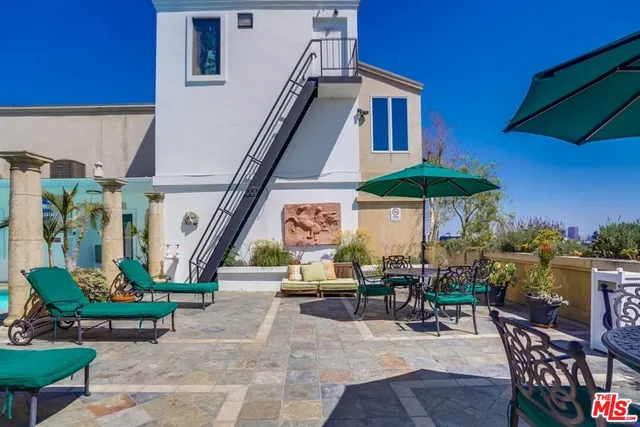 a view of a patio with couches table and chairs with potted plants and big yard