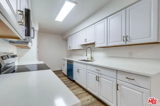 a kitchen with stainless steel appliances granite countertop a sink and a stove