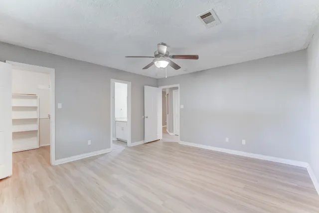 a view of an empty room and a ceiling fan window