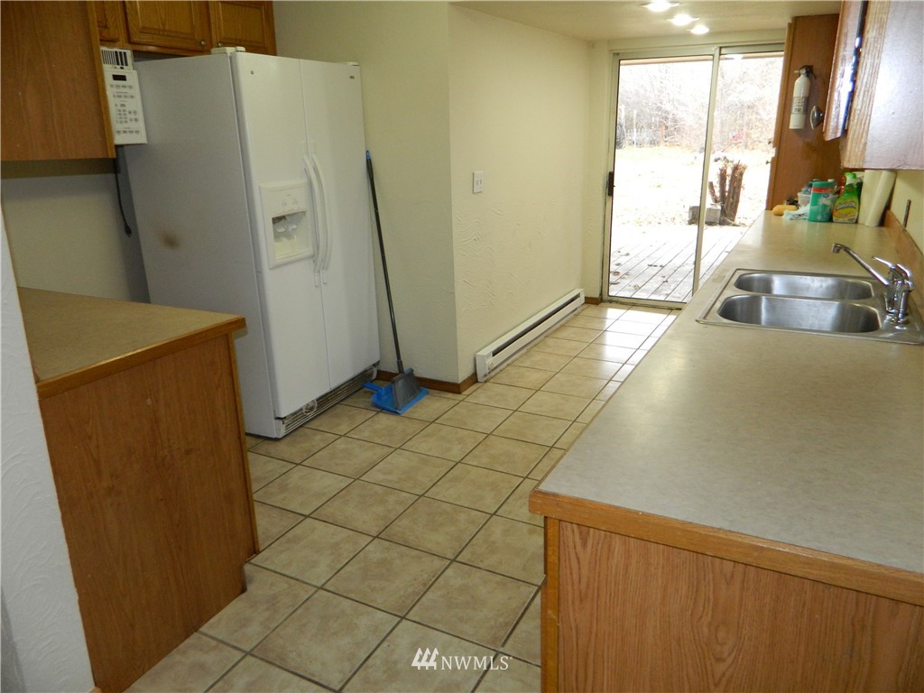 103 Cooper Street Riverside, WA 98849 - Photo 4 of 12 a kitchen with stainless steel appliances a refrigerator a sink a counter top space and cabinets