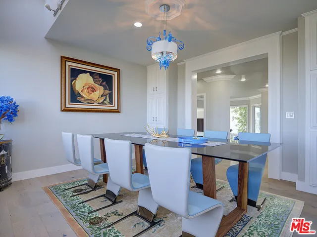 a view of a dining room with furniture a chandelier and wooden floor