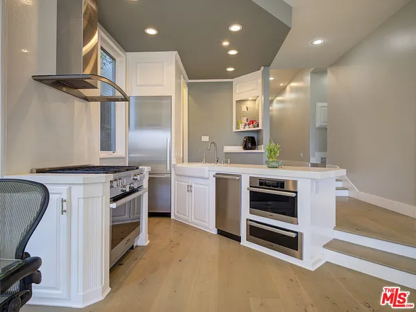 a kitchen with stainless steel appliances kitchen island granite countertop a stove a sink and a refrigerator